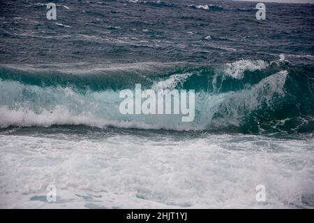 Une grande vague chevauche la côte de l'île croate de Losinj. Une vague qui s'écrase sur la côte rocheuse. Banque D'Images