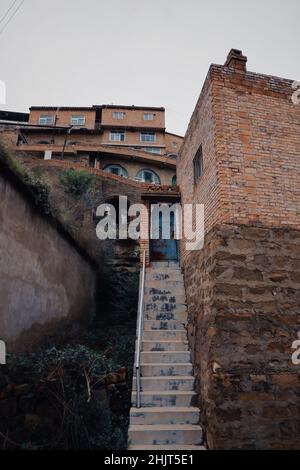 Plan vertical d'un escalier en pierre étroit menant à l'entrée d'un bâtiment dans la vieille ville Banque D'Images