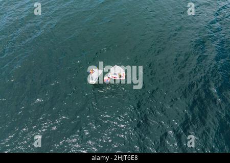 Drone aérien photo de jeunes adolescents sur de petits bateaux à voile en compétition dans la course à la mer émeraude de la Méditerranée Banque D'Images