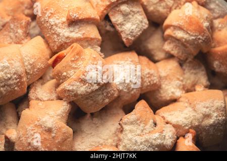 Biscuits bagels avec confiture en poudre de sucre dans une assiette sur fond sombre. Banque D'Images