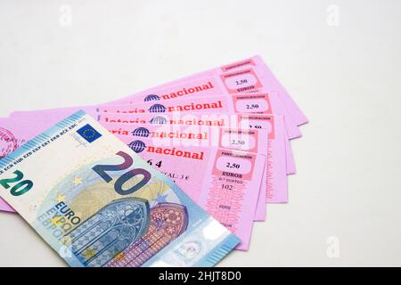 Image de certains billets de loterie nationaux à côté d'une facture de 20 euros avec un fond blanc et un espace de copie Banque D'Images