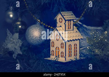 Maison en bois rétro avec lumière des fenêtres, comme une décoration sur l'arbre de Noël.Carte du nouvel an Banque D'Images