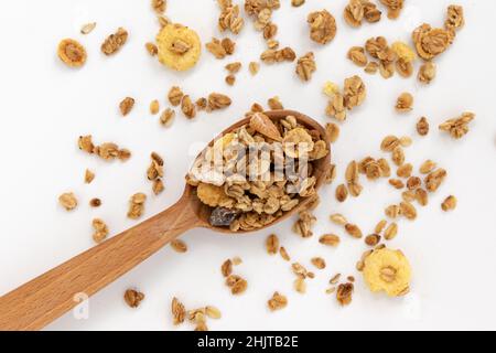 granola croquante dans une cuillère en bois isolée sur fond blanc, vue de dessus, concept de petit déjeuner sain Banque D'Images