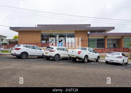 Une rangée de voitures blanches est garée à l'extérieur du bâtiment moderne du conseil local du milieu du siècle à Gloucester, Nouvelle-Galles du Sud, en Australie Banque D'Images