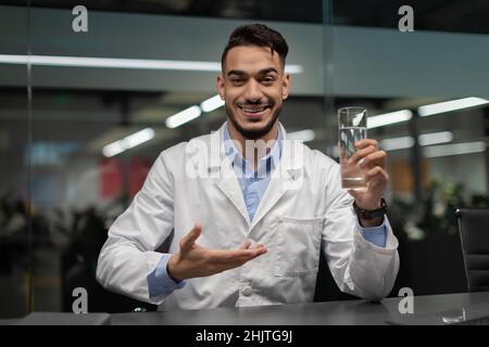 Beau médecin du Moyen-Orient tenant un verre d'eau Banque D'Images