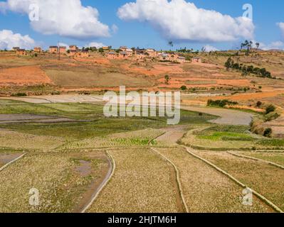 Superbe village bara perché (avec des maisons en boue et en paille) avec des champs cultivés colorés dans la vallée, Antsirabe, Madagascar Banque D'Images