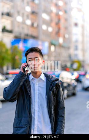 asiatique ayant une conversation à partir de son smartphone Banque D'Images