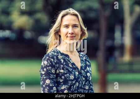 Portrait d'une femme caucasienne aux yeux bleus et aux cheveux blonds posant Banque D'Images