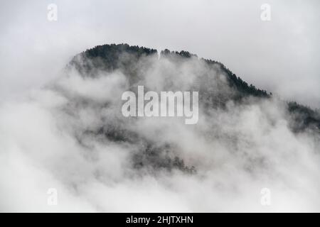 Montagne alpine recouverte d'un épais brouillard blanc. Banque D'Images