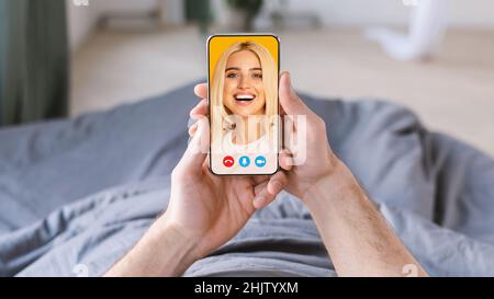 Jeune homme utilisant un smartphone pour discuter avec sa femme en ligne, couché au lit le matin, collage Banque D'Images