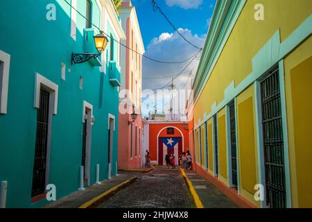 Touristes à côté d'une fresque du drapeau portoricain dans une rue pleine de maisons colorées, le vieux San Juan, Porto Rico Banque D'Images