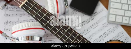 Écouteurs de guitare et notes musicales sur la table de clôture Banque D'Images