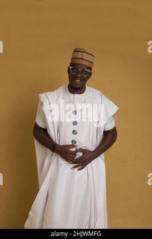 Un Babariga habillé traditionnellement Arewa Northern Business Man dans des lunettes expliquent heureusement Banque D'Images