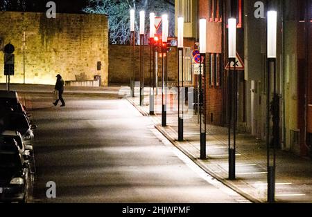 Hildesheim, Allemagne.01st févr. 2022.Un homme passe devant le ruban du patrimoine mondial entre la cathédrale de Hildesheim et l'église Saint-Michel en début de matinée.Credit: Julian Stratenschulte/dpa/Alay Live News Banque D'Images