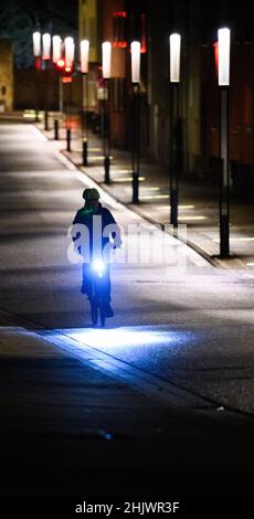 Hildesheim, Allemagne.01st févr. 2022.Les cyclistes passent devant le ruban du patrimoine mondial entre la cathédrale de Hildesheim et l'église Saint-Michel en début de matinée.Credit: Julian Stratenschulte/dpa/Alay Live News Banque D'Images