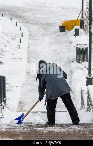 L'homme pelle la neige sur un escalier après une grosse tempête de neige, verticale Banque D'Images