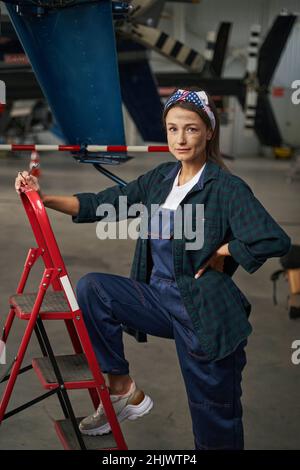 Magnifique femme caucasienne mécanicien de cellule debout dans le hangar Banque D'Images