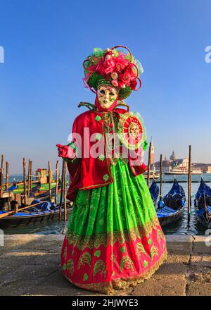 Femme en costume de fantaisie historique coloré, chapeau et masque pose au carnaval de Venise, Carnivale di Venezia, Vénétie, Italie Banque D'Images