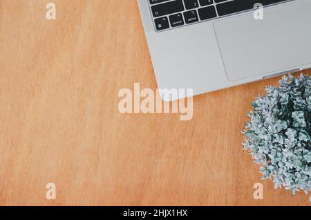Vue de dessus plat ordinateur portable et fleur sur la table en bois. Banque D'Images
