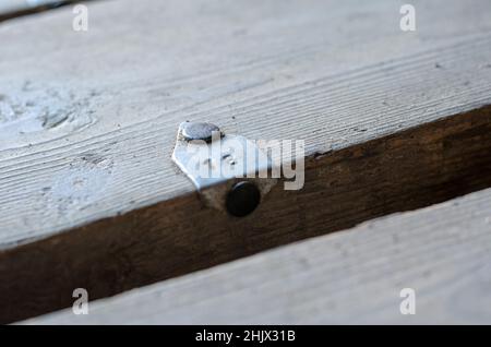 Un cliché défoqué du numéro 18 sur une ancienne planche.Panneau sale avec étiquette en aluminium.Barre métallique clouée au plancher.Gros plan.Mise au point sélective. Banque D'Images