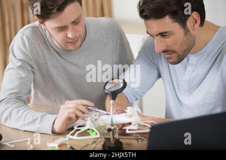 les hommes qui fixent l'hélice du drone à l'aide d'un tournevis à l'atelier Banque D'Images