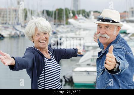 les bras des couples âgés s'ouvrent sur un port Banque D'Images