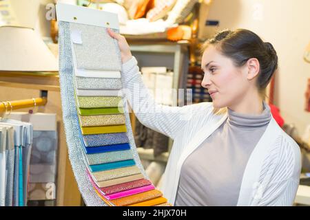 la femme choisit des échantillons de tissus colorés Banque D'Images