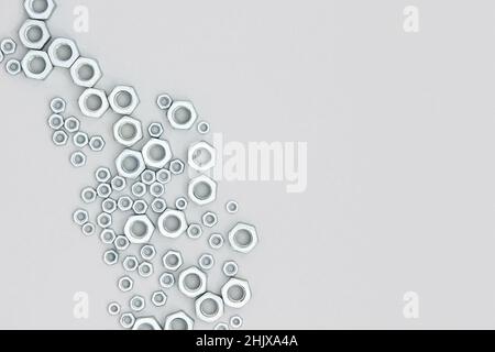Écrous hexagonaux métalliques sur fond gris.Bordure abstraite.Vue de dessus de l'espace de copie de la mise à plat. Banque D'Images