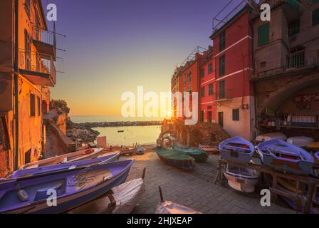 Rue du village de Riomaggiore, bateaux et mer au coucher du soleil, Parc national des Cinque Terre, région de Ligurie, Italie, Europe. Banque D'Images