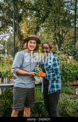 Portrait des femmes et des hommes souriants qui se tiennent dans le jardin Banque D'Images
