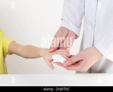 Les mains du médecin bandent le doigt douloureux avec un bandage de l'enfant.Blessure et blessure au doigt chez les enfants Banque D'Images