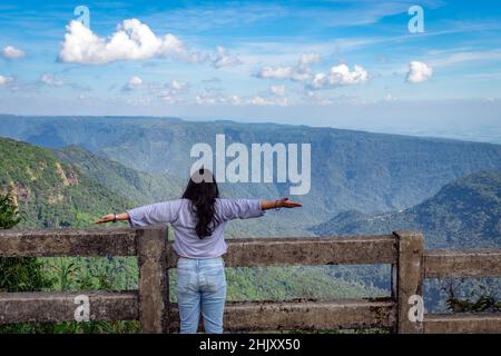 jeune fille appréciant la chaîne de montagnes avec ciel bleu vif l'après-midi de l'image d'angle plat est prise à sept soeur cascade cherrapunji meghalay Banque D'Images