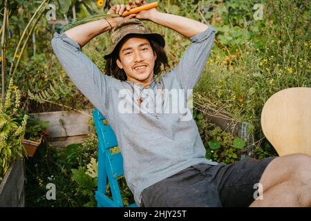 Portrait d'un fermier mâle assis dans le jardin de la communauté Banque D'Images