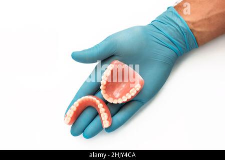 Prothèse de dents fausses.Médecin dentiste.Un dentiste tient une fausse mâchoire dans sa main.Prothèse dentaire dans les mains du médecin en gros plan.Bosselure Banque D'Images