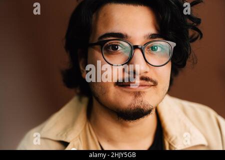 Portrait d'un homme portant des lunettes en studio Banque D'Images