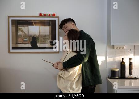 Jeune couple regardant le cadre photo suspendu au mur Banque D'Images