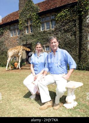 BRYONY ET RICK ANDERSON À L'EXTÉRIEUR DE GIRAFFE MANOR.DANS LEUR MAISON DE MANOIR À NAIROBI, KENYA, LES ANDERSONS ONT PLUS D'UNE DOUZAINE DE GIRAFES SAUVAGES, QUI VIENNENT DEUX FOIS PAR JOUR ET METTENT LEUR TÊTE PAR LES FENÊTRES ET LES PORTES DU MANOIR POUR AVOIR LEUR COLLATION PRÉFÉRÉE DE FRUITS FRAIS.LES GIRAFES ROTHSCHILD ONT ÉTÉ RÉDUITES À MOINS DE 150 DANS LE MONDE, MAIS AVEC L'AIDE DES EFFORTS DE GIRAFFE MANOR, LA POPULATION MONDIALE A AUGMENTÉ À 350.PHOTO : GARYROBERTSPHOTO.COM Banque D'Images