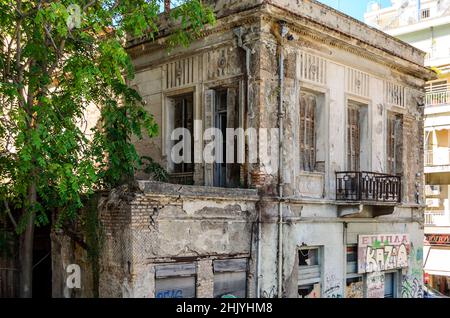 Ancienne maison néoclassique à deux étages en délabré dans le centre-ville de Patras, en Grèce, le jour du soleil. Résidence abandonnée avec grandes fenêtres, cour et balcon. Banque D'Images