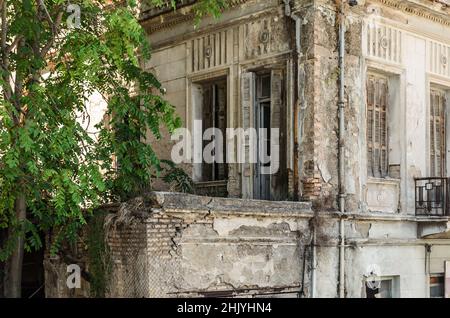 Ancienne maison néoclassique à deux étages en délabré dans le centre-ville de Patras, en Grèce, le jour du soleil. Résidence abandonnée avec grandes fenêtres, cour et balcon. Banque D'Images