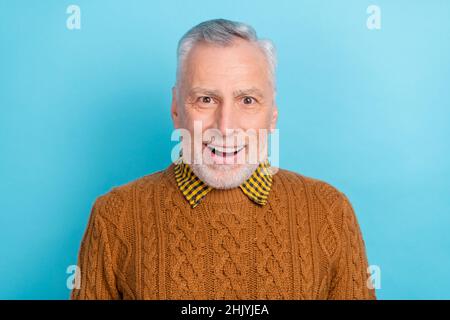 Photo de l'homme doux impressionné retraité porter un chandail brun à bouche ouverte isolé couleur bleue fond Banque D'Images