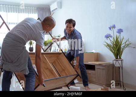 deux menuiserie de sexe masculin assemblent de nouveaux meubles ensemble Banque D'Images