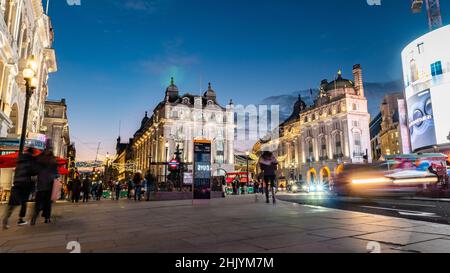 Piccadilly Circus, Londres, Angleterre. Une vue créative à la tombée de la nuit du quartier touristique du centre de Londres avec circulation et piétons flous. Banque D'Images