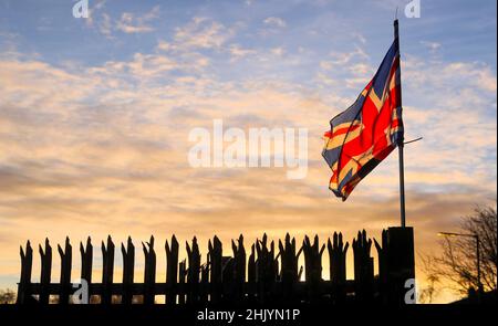 Le soleil se lève sur Belfast est tandis que le drapeau de l'Union flotte dans le vent. Banque D'Images