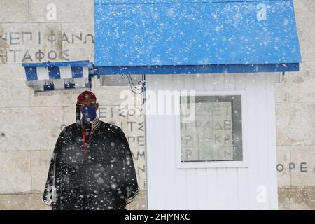 La garde présidentielle, connue sous le nom d'Evzonas, se tient pendant une forte chute de neige dans le centre d'Athènes. Banque D'Images