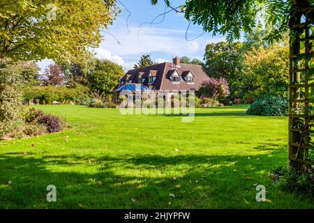 Burrough Green, Suffolk - octobre 11 2016: Vue de la maison traditionnelle de suffolk pays substantiel dans de grands jardins y compris la grande pelouse et Banque D'Images