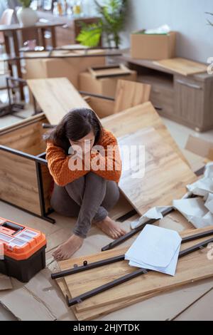 femme asiatique frustrée lors de l'assemblage de nouveaux meubles Banque D'Images