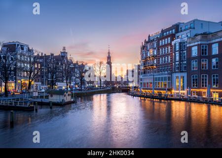 Vue sur un canal d'Amsterdam au coucher du soleil avec de l'Europe Hotel bars avec restaurants, vélos garés, Amsterdam Hollande Banque D'Images