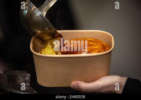 Gros plan de la sauce versée sur la tarte et la purée de pommes de terre et servi dans un bain écologique. Banque D'Images