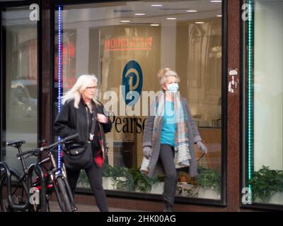 Les navetteurs passant devant le siège de la société d'enseignement Pearson avec des masques Covid EPI dans le centre de Londres, Pearson plc est une société d'édition et d'enseignement britannique avec des bureaux à Londres. Banque D'Images