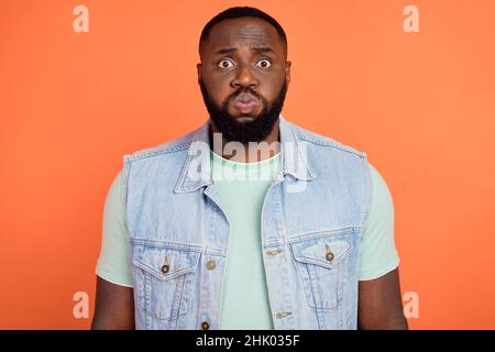 Photo d'un Africain maltraité Jean habillé gilet de costume joues gonflées isolé couleur orange arrière-plan Banque D'Images